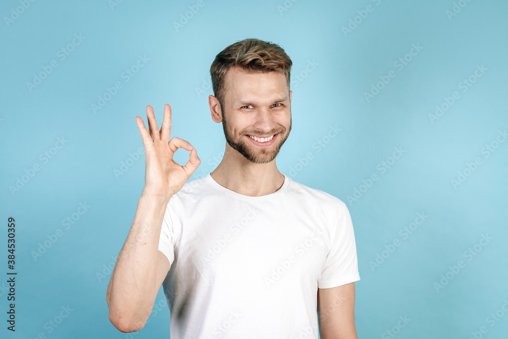 Young adult guy making okay sign and smiling nice Young adult guy making okay sign and smiling nice