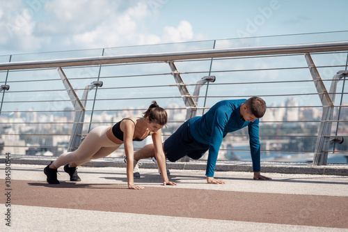 Fototapeta Naklejka Na Ścianę i Meble -  Man and woman making sport training outdoors together