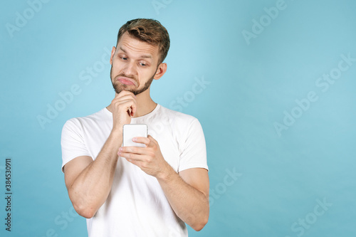 Young adult man reading interesting news on smartphone