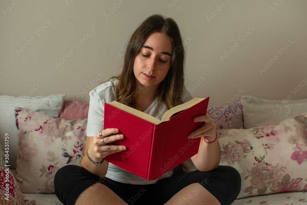 Chica leyendo en libro en su dormitorio Chica leyendo en libro en su dormitorio