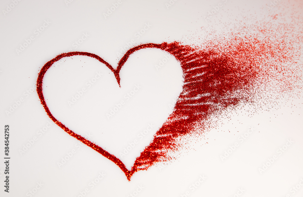 Glitter heart dissolving into pieces on bright background. Valentines day, broken heart and love emergence concept. Glitter heart dissolving into pieces on bright background. Valentines day, broken heart and love emergence concept.