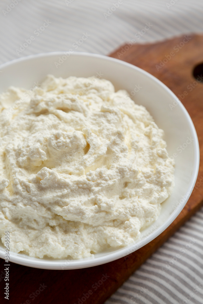 Tasty Ricotta Cheese in a White Bowl, side view. Close-up.