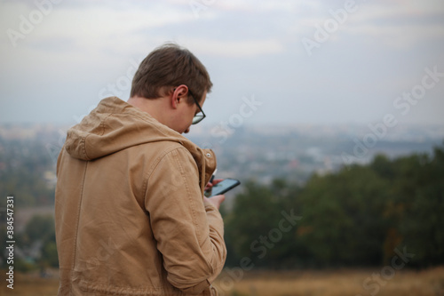 the man looks at the phone and flips the news feed