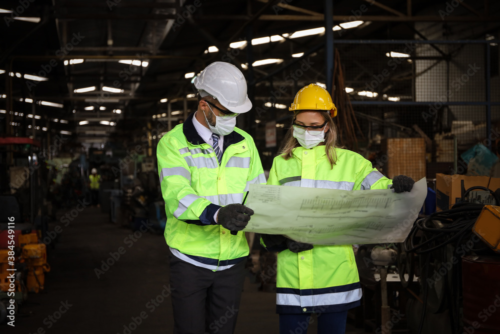 Manager or supervisor wear face mask talking or discussing with engineering team or worker about electrical drawing of machine control and operate in manufacturing factory, Covid or virus protection Manager or supervisor wear face mask talking or discussing with engineering team or worker about electrical drawing of machine control and operate in manufacturing factory, Covid or virus protection