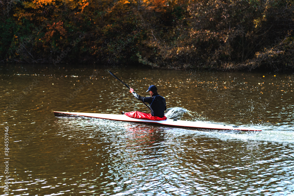 young athletic man training on his kayak canoe in autumn young athletic man training on his kayak canoe in autumn