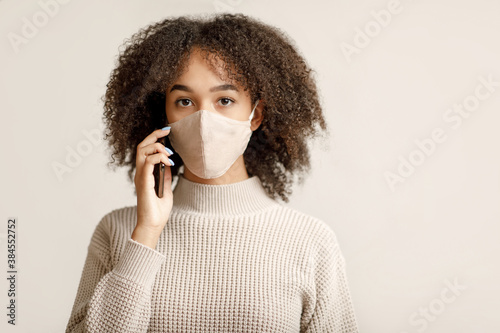 Quarantine, social distance and remote communication. Young african american lady talking on phone © Prostock-studio