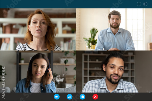 Screen application view of diverse multiracial businesspeople talk speak on video call, engaged in team online meeting. Multiethnic colleagues have webcam group virtual conference or web briefing. photo