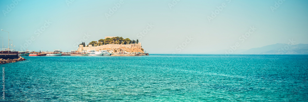old castle on promontory of sea with blue calm water seascape