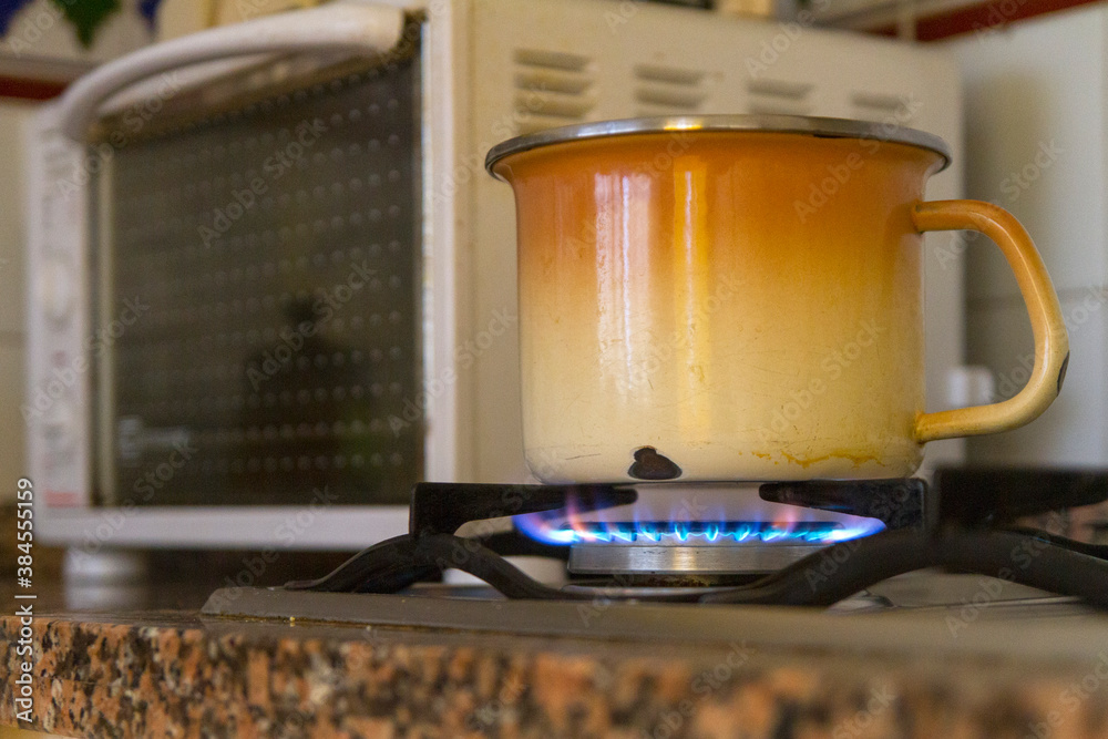 Cazuela u olla calentando comida al fuego de la hornilla y microondas Stock  Photo | Adobe Stock