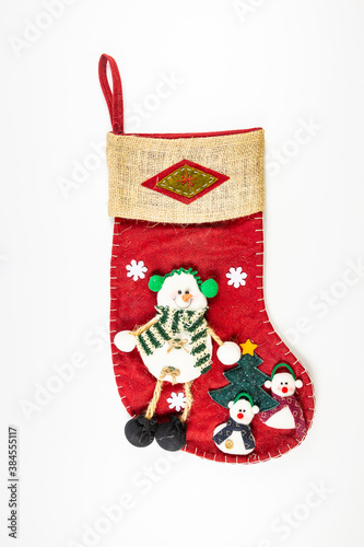 red Christmas stocking with three snowmen and a small tree (used for decoration) isolated on a white background