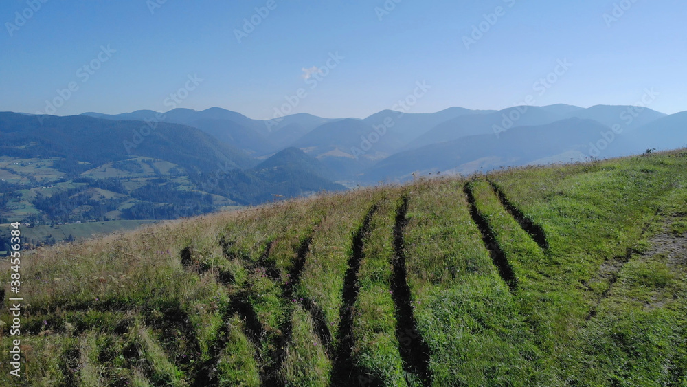 Deep traces on the grass. Lovely landscape of mountains.