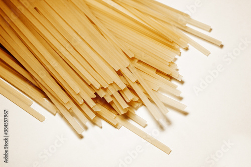 Raw vermicelli pasta background. raw yellow vermicelli is scattered on the table. short raw yellow vermicelli for cooking