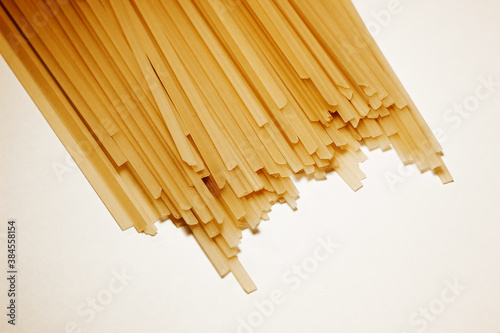 Raw vermicelli pasta background. raw yellow vermicelli is scattered on the table. short raw yellow vermicelli for cooking