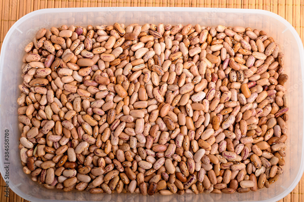 Natural background of many fresh organic red beans in a plastic box in warm light, top view or flat lay of organic vegan food photographed with soft focus Natural background of many fresh organic red beans in a plastic box in warm light, top view or flat lay of organic vegan food photographed with soft focus