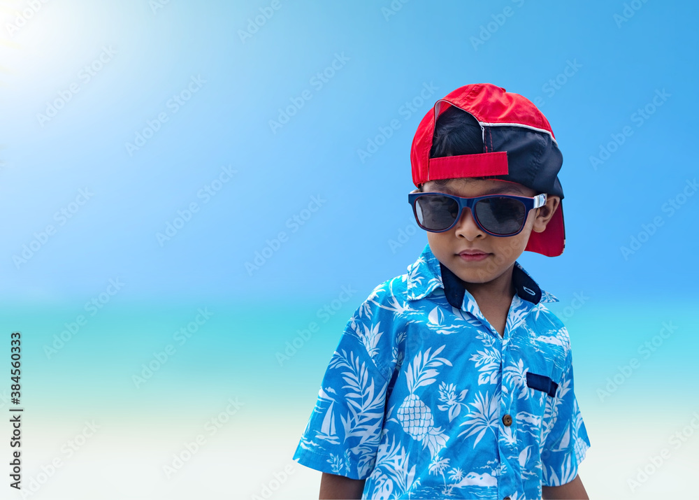 Asian boys wear sunglasses and summer clothes on a bright summer sea background. Asian boys wear sunglasses and summer clothes on a bright summer sea background.