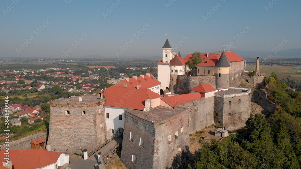 Old historical castle on the green hill. Romantic view of medieval fortress. Panorama of city landscape.