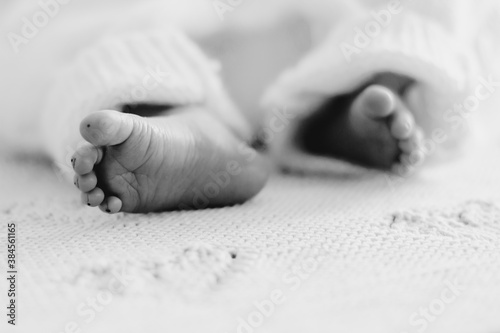 Detail of newborn's feet in mother's hands - shallow DOFnClose-up feet of a newborn baby. Young mother is holding baby feet in his hisands.