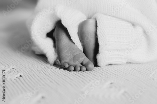 Detail of newborn's feet in mother's hands - shallow DOFnClose-up feet of a newborn baby. Young mother is holding baby feet in his hisands.