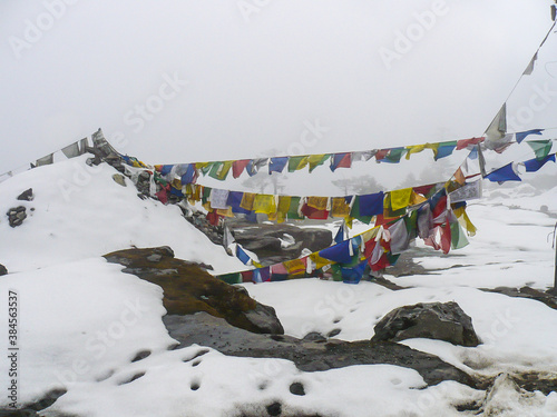Buddhist prayer flags on a snow capped mountain