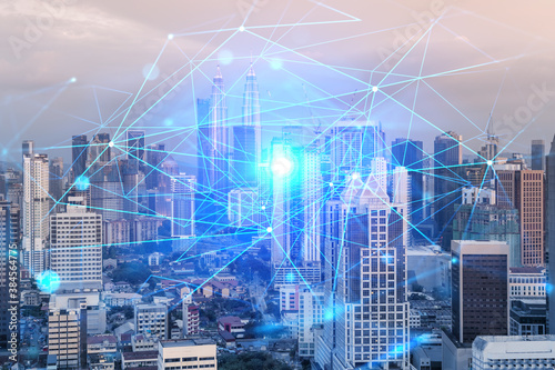 Photography Hologram of abstract technology glowing icons, panoramic cityscape of Kuala Lumpur at sunset, Malaysia, Asia