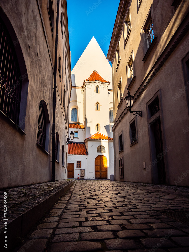 Empty cobblestoned street in Prague's Old Town historic district leading to former monastery building