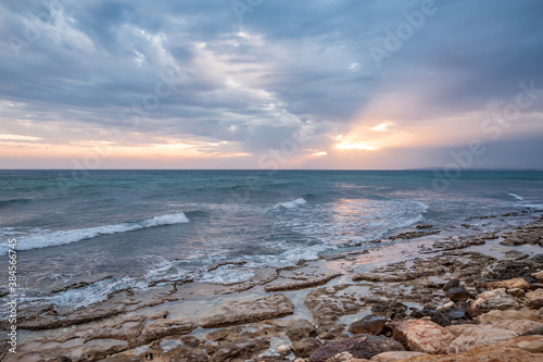 Fototapeta Naklejka Na Ścianę i Meble -  Sunset on the background of the rocky seashore.