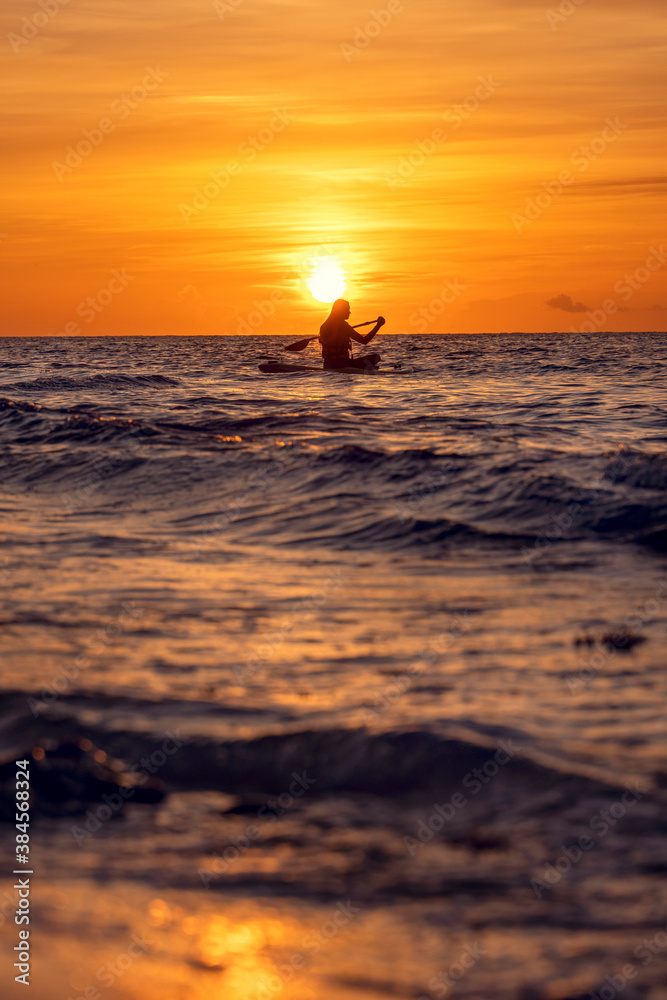 Mujer kayak en el amanecer
