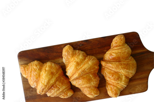 homemade croissants on wooden cutting board isolated on white background