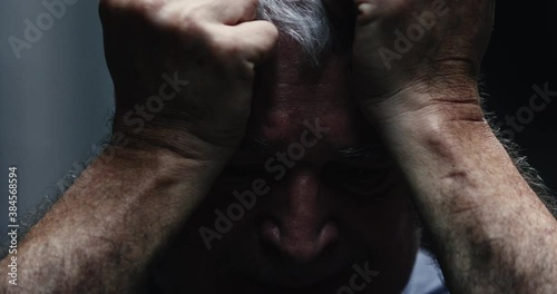 Dramatic depressed older man in agony. 60 year old man suffering mental distress