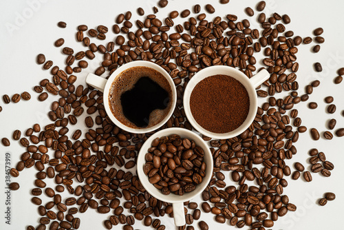 Three cups of coffe with naturel coffe beans as background.