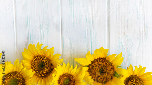 Postcard with flowers of a sunflower on a light wooden background. Frame for text for Thanksgiving, birthday. Background with autumn flowers for website, banner