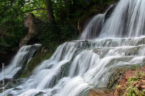 Fototapeta Naklejka Na Ścianę i Meble -  Scenic view of cascading 16 meters Dzhurinsky waterfall on the river Dzhurin. It is the largest in Ukraine plain waterfall. Nyrkiv, Ternopil region, Ukraine