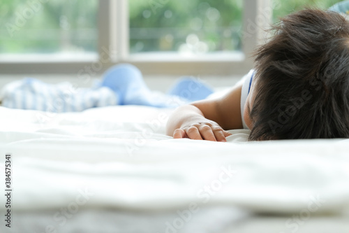 Asian baby is sleeping with face down on white linens.