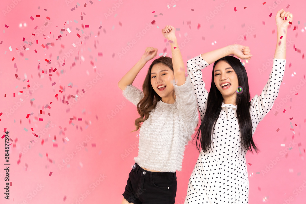 Fototapeta premium Portrait of two lovely cute asian women in christmas hats looking at camera isolated over pink background.Attractive asian woman smile in christmas, new year, valentine day, birthday .