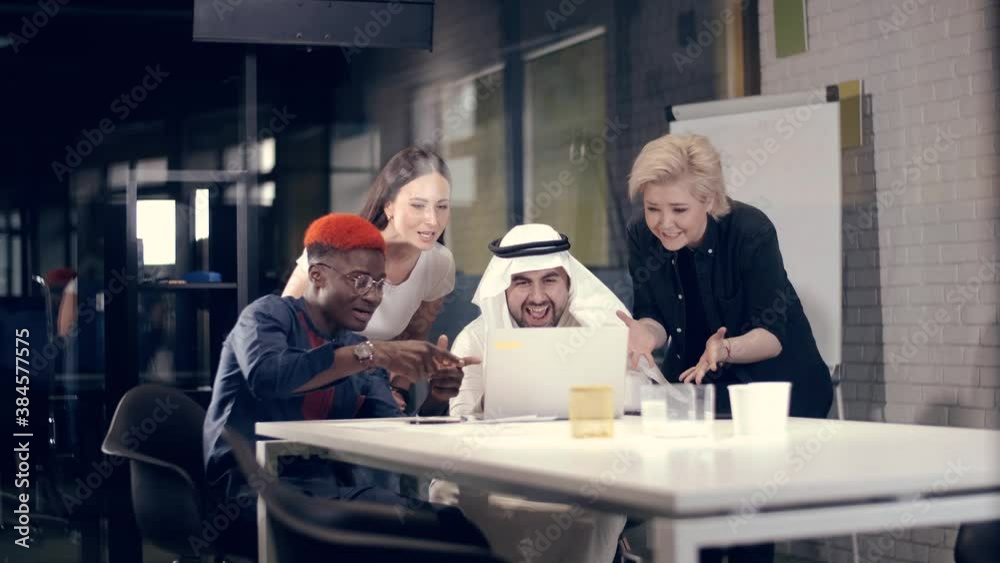 Creative people of different nationalities rejoice and rejoice at the success of the new business project. Concept of successful team work.