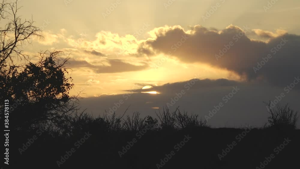 Yellow Sun Setting Behind Clouds with God Rays in the Galapagos Islands Yellow Sun Setting Behind Clouds with God Rays in the Galapagos Islands