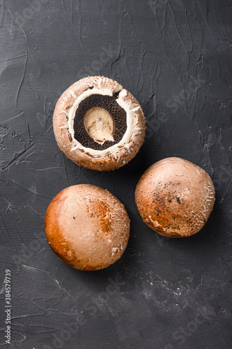 Ripe portobello mushrooms set on black background top view.
