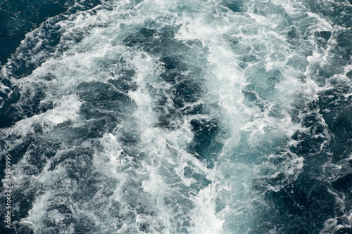 Waves and white foam at the sea. Watching the blue water building pattern. 