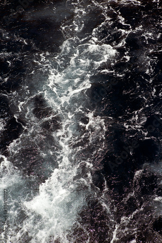 Waves and white foam at the sea. Watching the blue water building pattern. 
