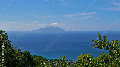 Panoramic view from Dans Gallas hiking trail in the north of Mahe  Seychelles over the northern coastline with the silhouettes of Silhouette Island and Ile du Nord on the horizon.