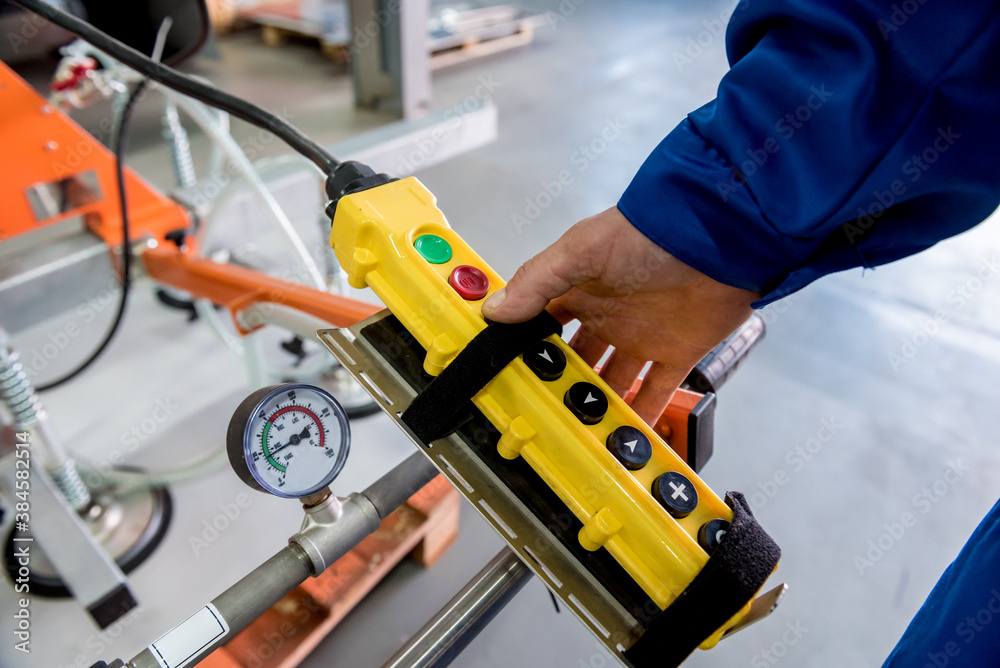 Worker uses suction cups for transporting large sheets of metal Worker uses suction cups for transporting large sheets of metal