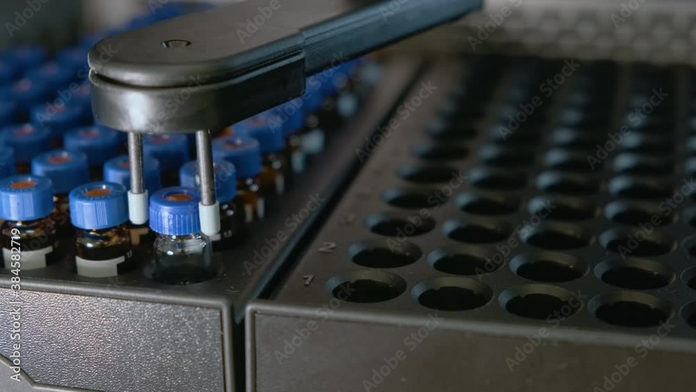 Auto sampler takes a vial and injects a sample into high performance ...