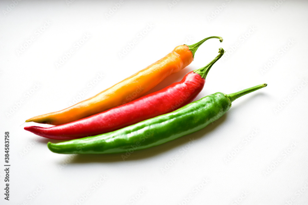 Yellow red and green capsicum on a white background