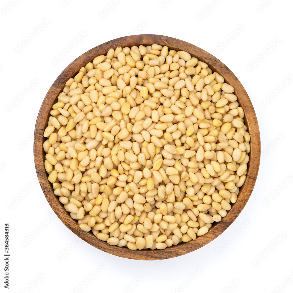 Wooden bowl with peeled pine nuts isolated on white background,