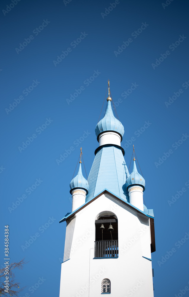 A Church with blue domes against a clear blue sky on a Sunny day.