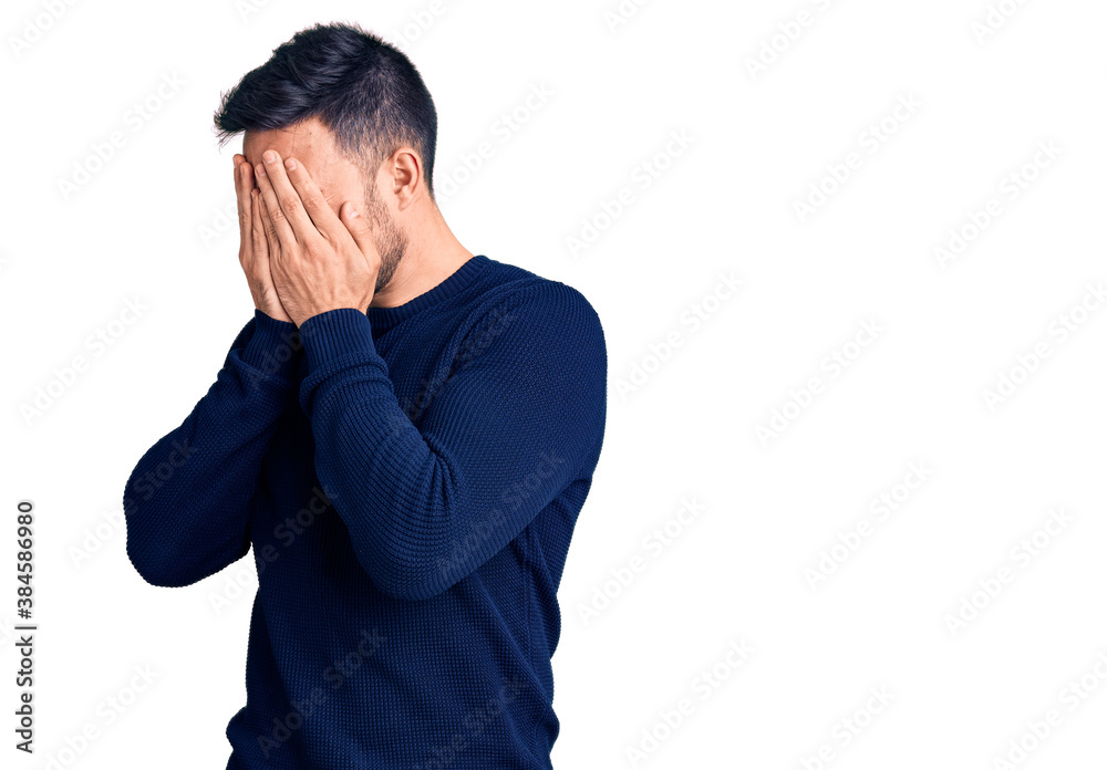 Young handsome man wearing casual clothes with sad expression covering face with hands while crying. depression concept.