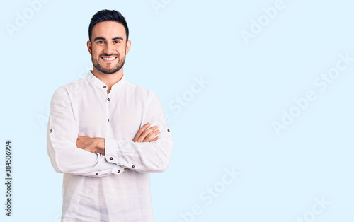 Young handsome man wearing casual clothes happy face smiling with crossed arms looking at the camera. positive person.