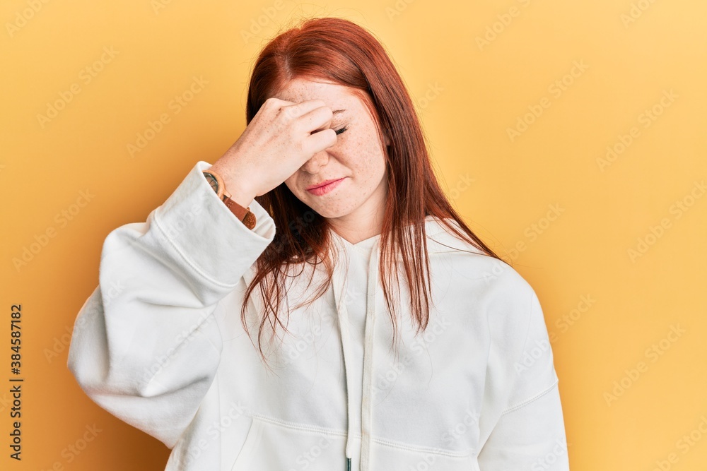 Young red head girl wearing casual sweatshirt tired rubbing nose and eyes feeling fatigue and headache. stress and frustration concept. Young red head girl wearing casual sweatshirt tired rubbing nose and eyes feeling fatigue and headache. stress and frustration concept.