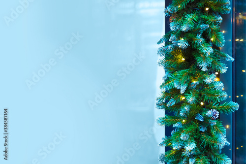 Christmas window dressing, copy space. Garland of green fir branches and cones, luminous garland, frame
