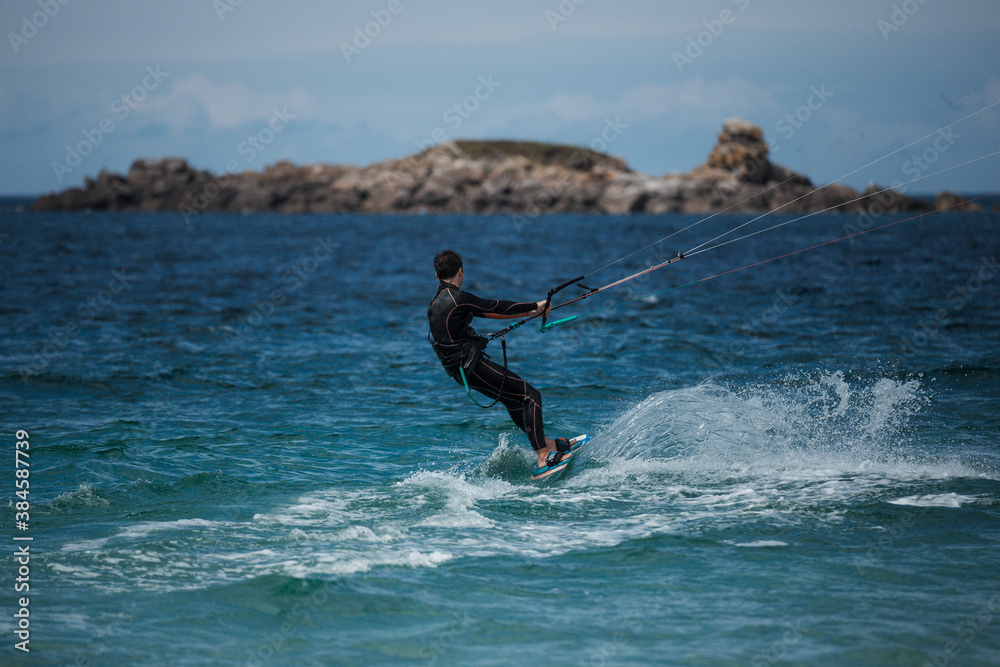 A man is pulled out of the water by his kite while kitesurfing